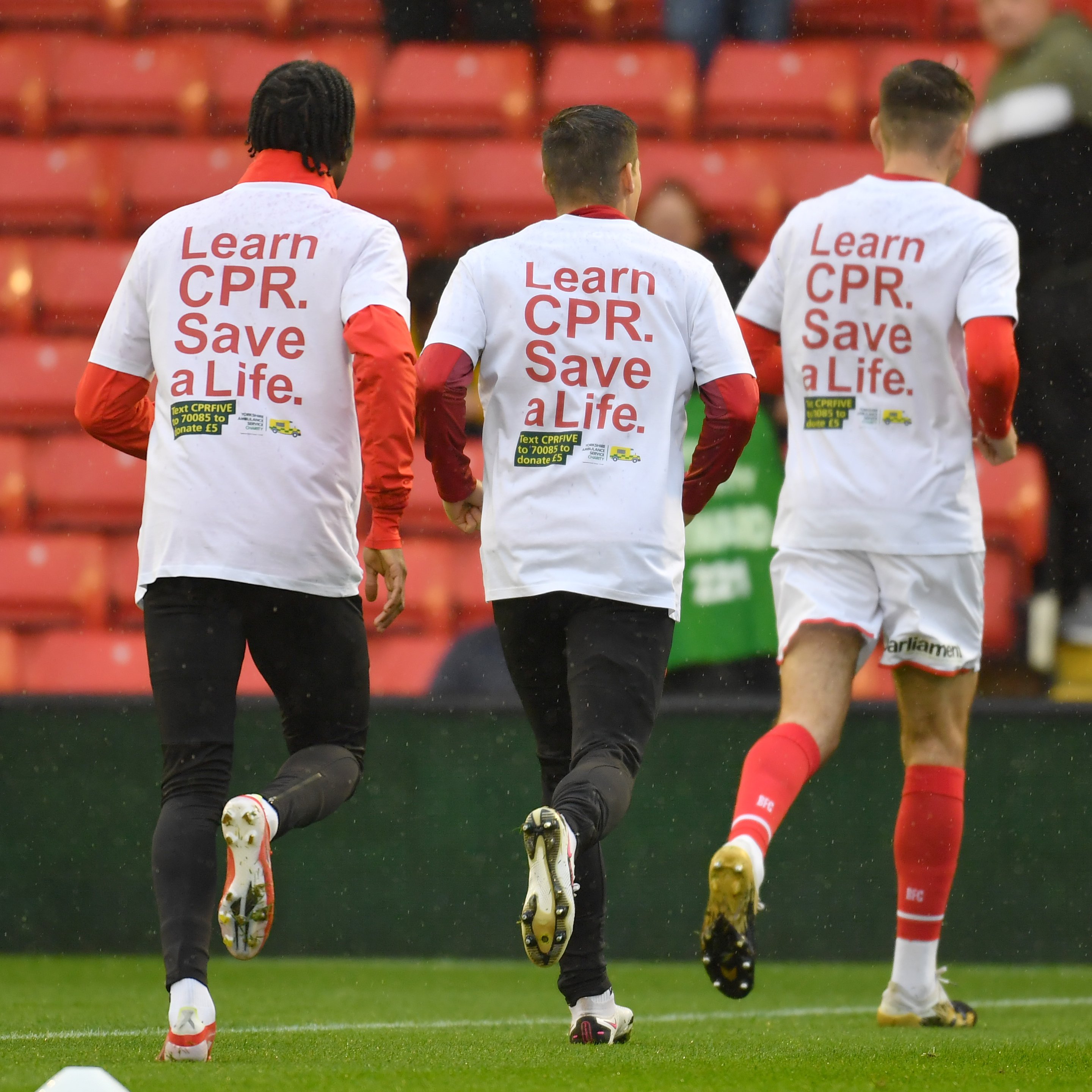 Barnsley FC players warming up wearing the Learn CPR. Save a Life t-shirts.